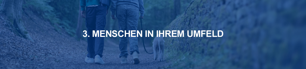 Zwei Menschen und Hund im Wald